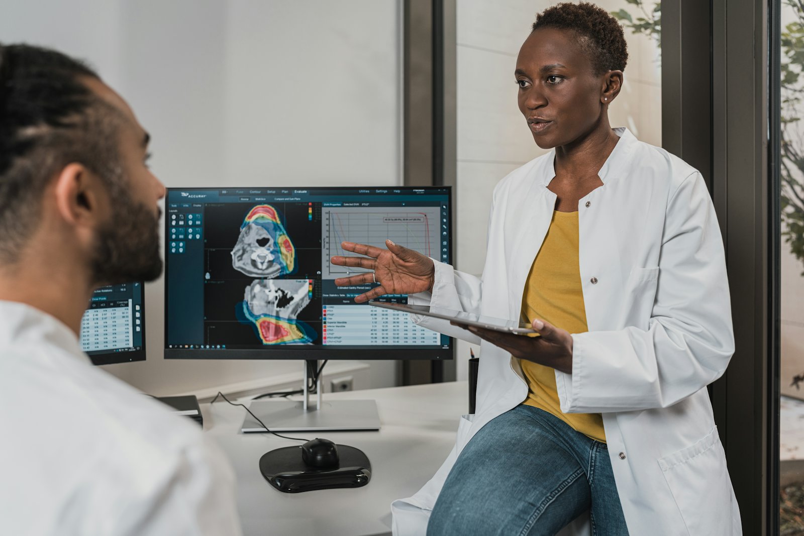 Two doctors discussing a patient's scans on a monitor