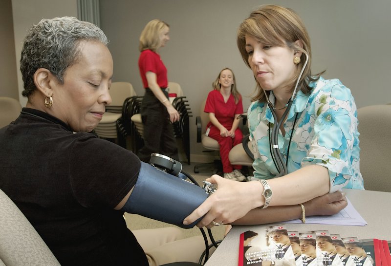 A nurse checking a patient's blood pressure