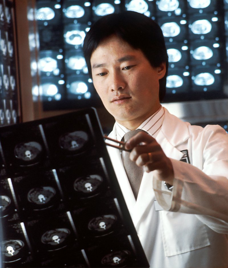 A radiologist studying scan films on a light box