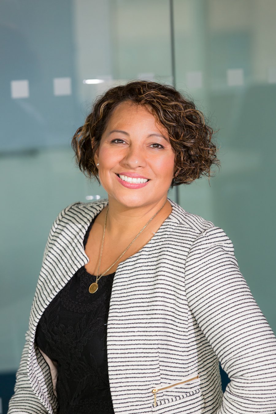 A smiling woman in a striped jacket